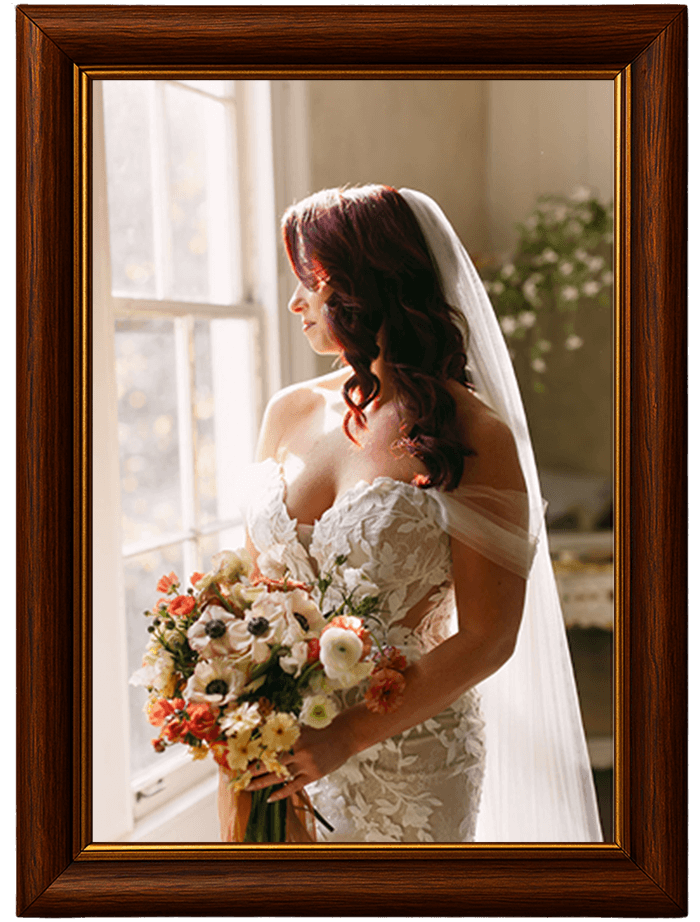 A bride holding flowers while looking out the window